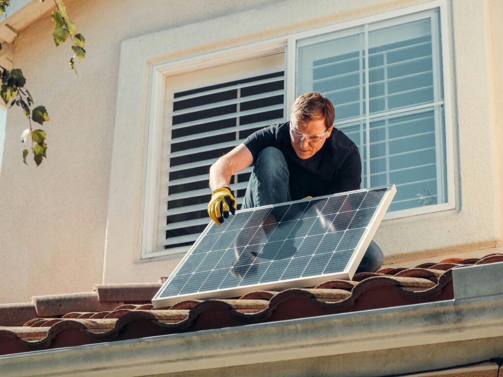 Worker kneeling down installing a solar panel